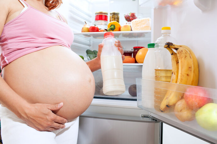 Schwangere vor dem Kühlschrank