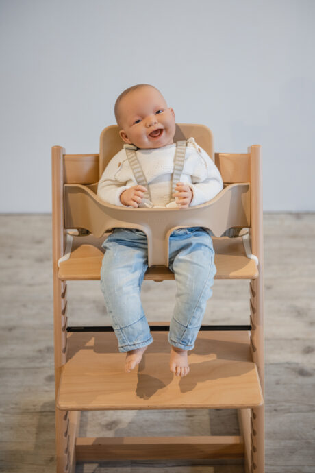 baby angeschnallt sitzt auf hochstuhl im baby set von stokke