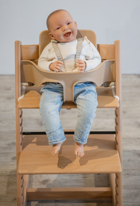 baby angeschnallt sitzt auf hochstuhl im baby set von stokke