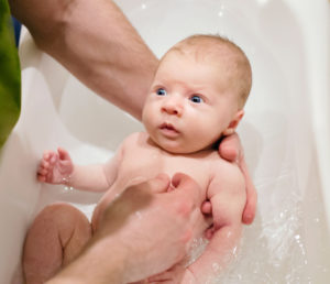 Baby Baden - klassischer Badegriff - Baby beim Baden halten
