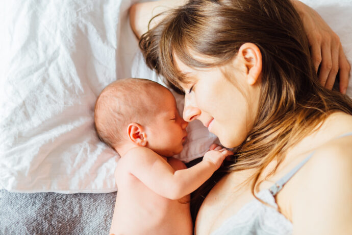 self care selbstfürsorge im wochenbett mutter und neugeborenes baby schlafen nebeneinander im bett