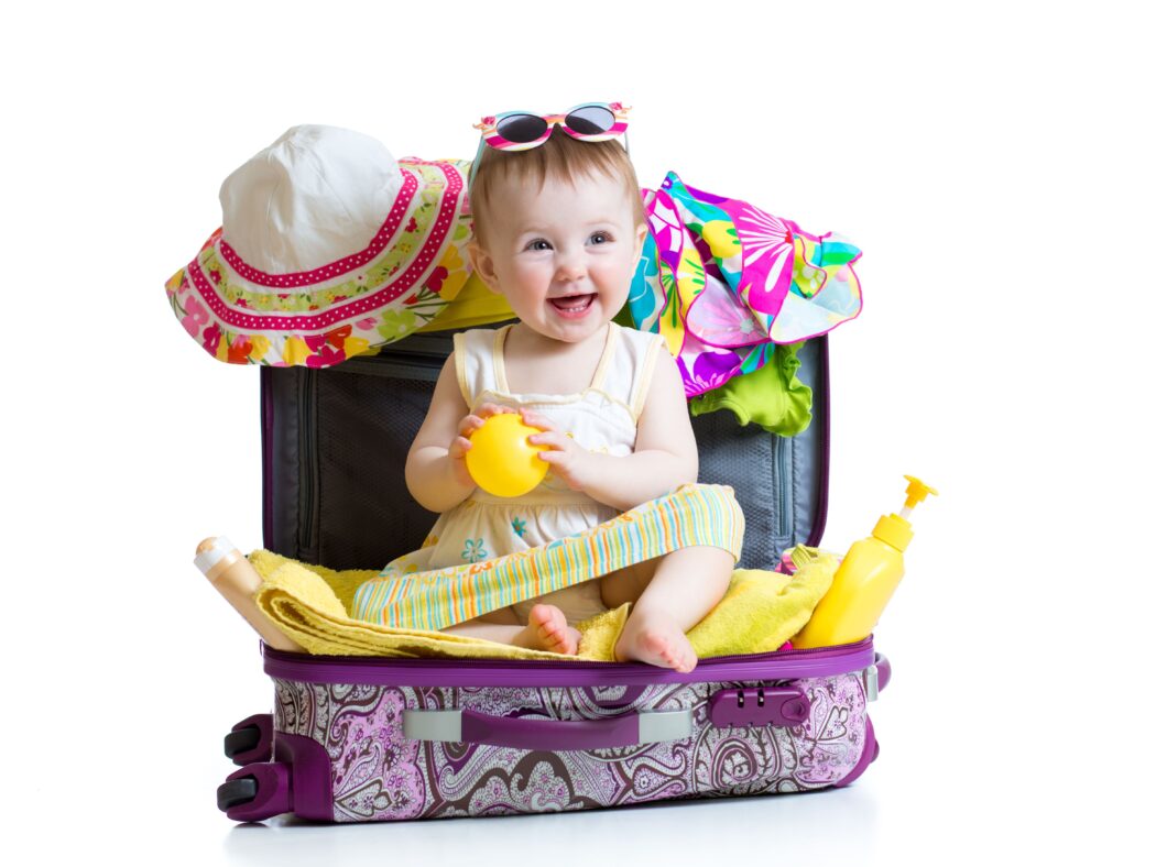 packliste urlaub baby sitzt fröhlich im koffer mit sonnenbrille bereit für reise