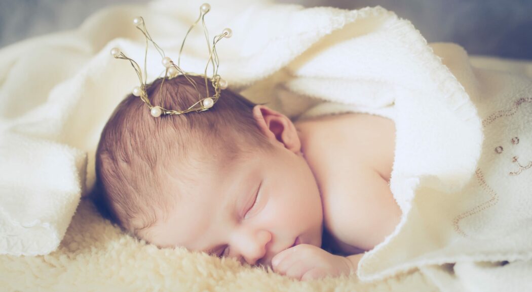 glückwünsche zur geburt schlafendes neugeborenes mädchen mit perlen krone auf lammfell