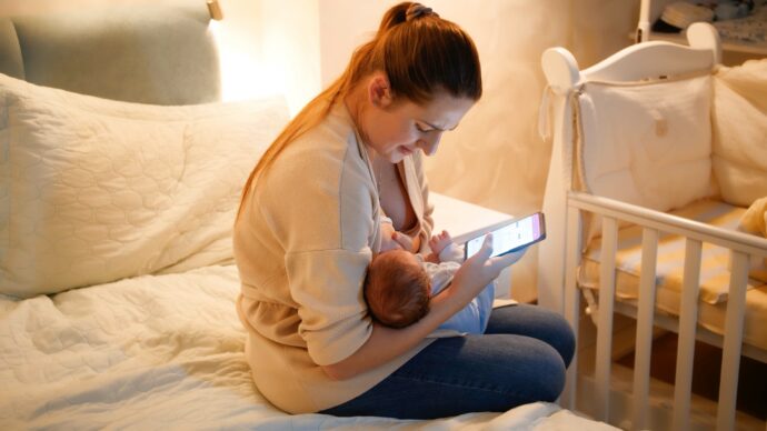 handy beim stillen schädlich für baby, smartphone beim stillen, mutter stillt baby und schaut auf handy