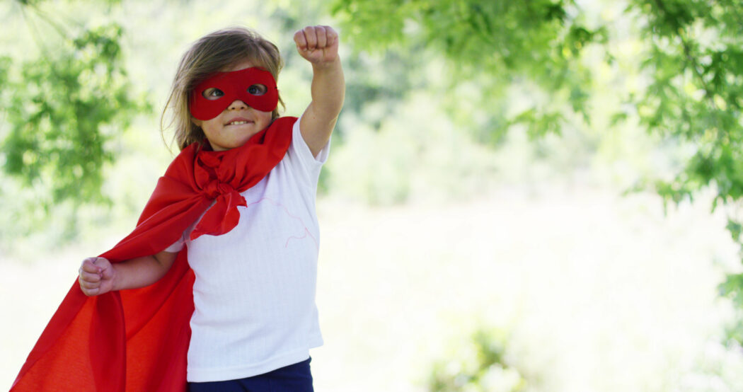 mädchen ist stark im superman kostüm symbol für resilienz kinder